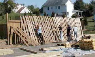 A team builds a fence between the neighboring Westover community and the still-under-construction Shadowlake Village, per town of Blacksburg requirements.